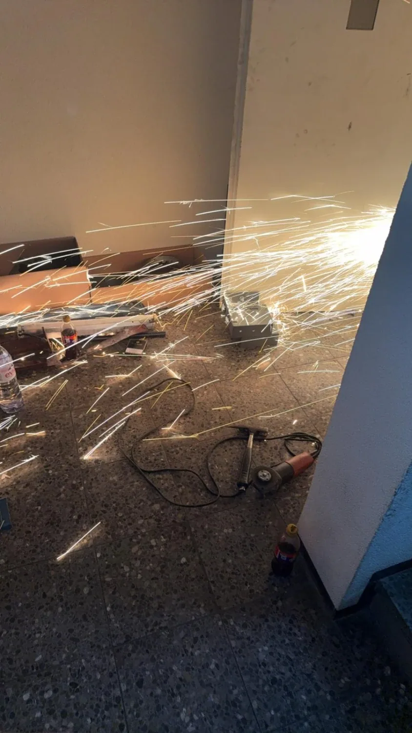 Trennschleifer im Einsatz auf einer Baustelle, Funkenflug über dem Boden