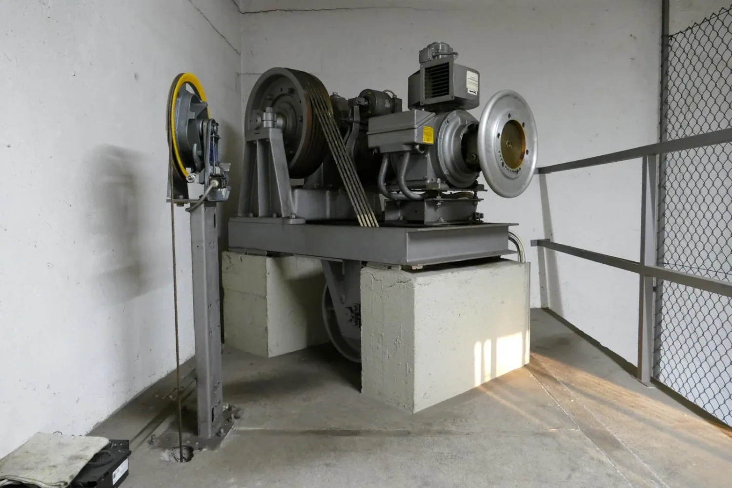 Treibscheibenmaschine mit Keilriemen und Schwungscheibe auf Betonsockeln im Triebwerksraum