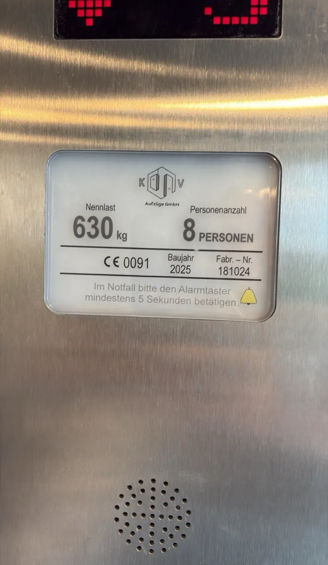 Typenschild mit dem Logo der KV Aufzüge GmbH in einer Aufzugskabine: Nennlast 630 kg, 8 Personen, CE 0091, Baujahr 2025, Fabr.-Nr. 181024